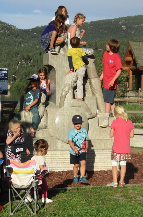 Children at the Evergreen Lake Concert enjoy climbing on the “Spirit of the Land” sculpture outside the Evergreen Lake House.